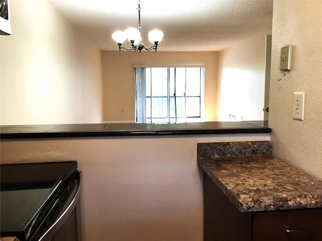 2625 State Road 590 Unit 1822, Clearwater, FL 33759 - kitchen with decorative light fixtures, dark countertops, a chandelier, a textured wall, and electric range