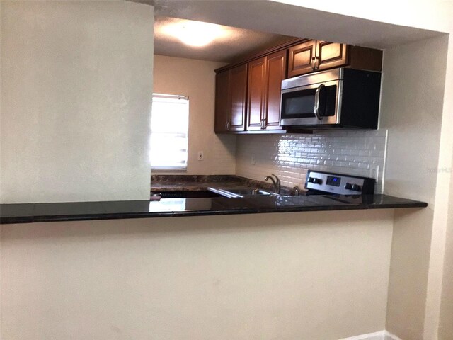2625 State Road 590 Unit 1822, Clearwater, FL 33759 - kitchen with stainless steel microwave, a sink, backsplash, and dark countertops