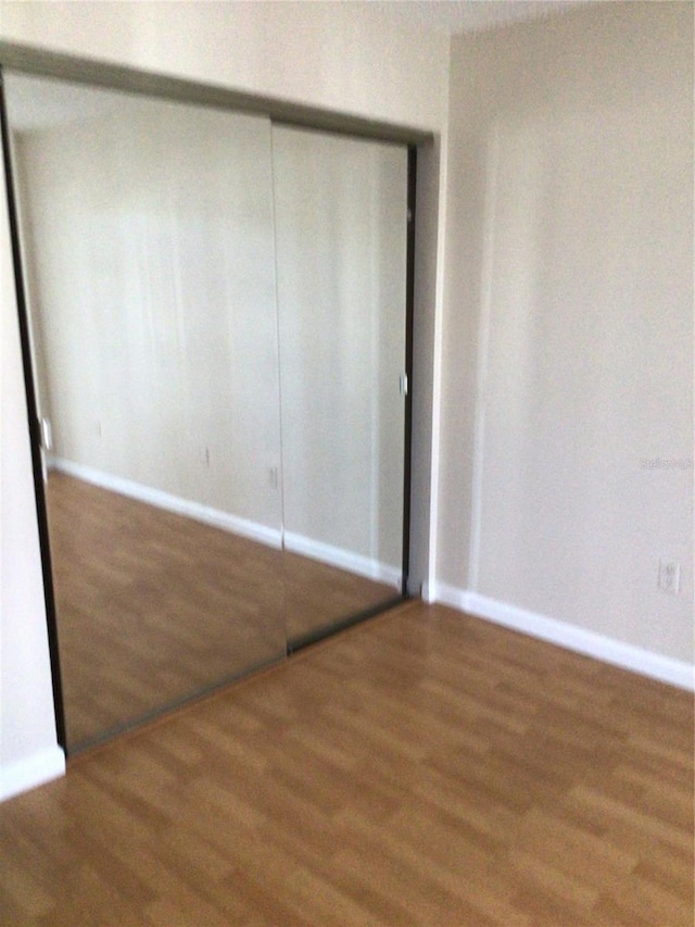 2625 State Road 590 Unit 1822, Clearwater, FL 33759 - unfurnished bedroom featuring wood finished floors, a closet, and baseboards