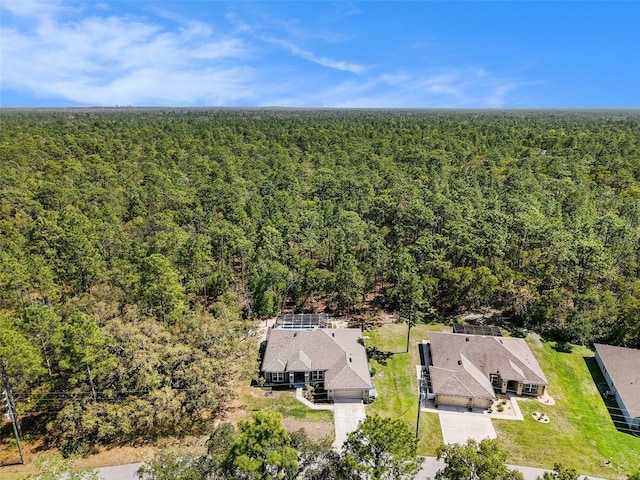 bird's eye view with a wooded view