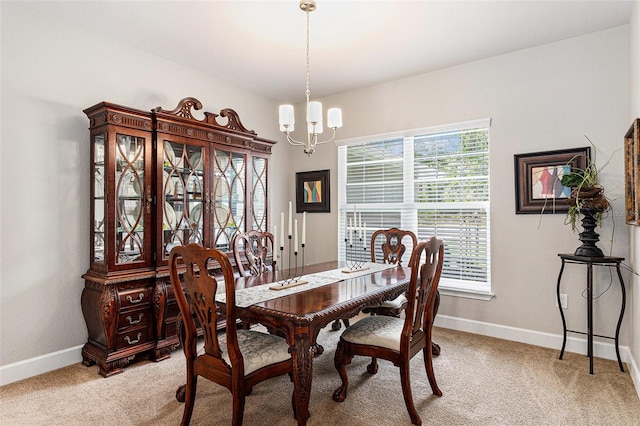 dining area featuring baseboards, a notable chandelier, and light carpet