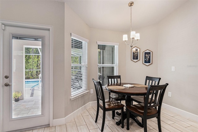 dining room featuring a chandelier, baseboards, and wood finish floors