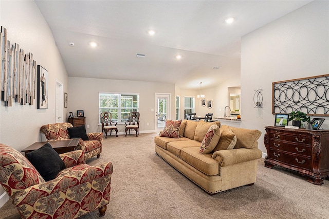 carpeted living area featuring baseboards, recessed lighting, visible vents, high vaulted ceiling, and a sink