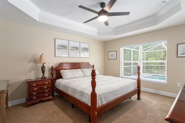 bedroom featuring a raised ceiling, light carpet, baseboards, and ornamental molding