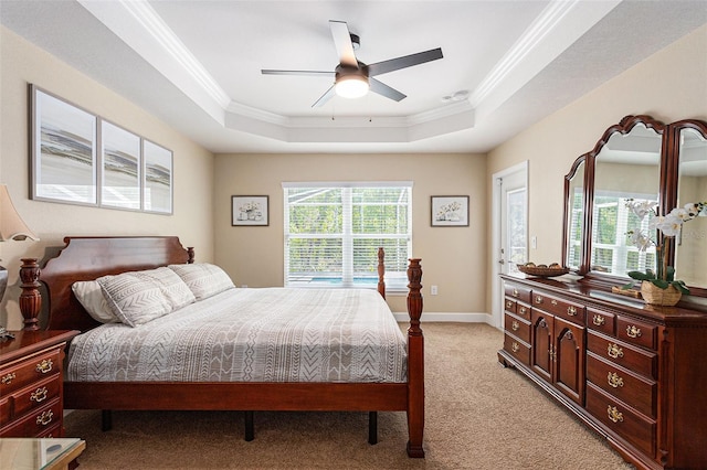 bedroom featuring light carpet, baseboards, crown molding, and a raised ceiling