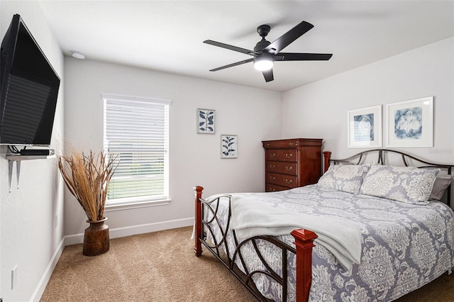 carpeted bedroom with ceiling fan and baseboards
