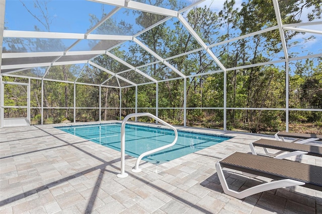 outdoor pool with a patio area and glass enclosure