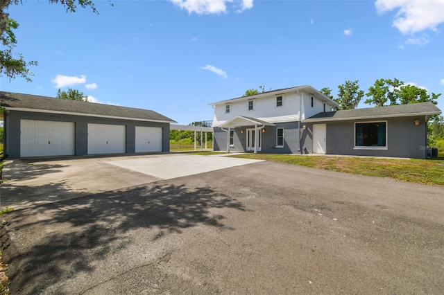traditional-style home with brick siding, cooling unit, an outbuilding, and a garage