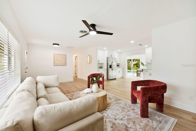1886 San Mateo Dr, Dunedin, FL 34698 - living room featuring baseboards, a ceiling fan, and light wood-style flooring