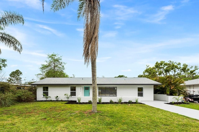 1886 San Mateo Dr, Dunedin, FL 34698 - ranch-style house featuring a front lawn and stucco siding