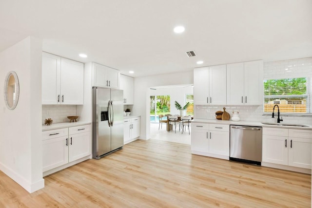 1886 San Mateo Dr, Dunedin, FL 34698 - kitchen with tasteful backsplash, a sink, light countertops, appliances with stainless steel finishes, and visible vents