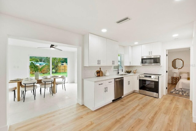 1886 San Mateo Dr, Dunedin, FL 34698 - kitchen featuring decorative backsplash, light countertops, a sink, and appliances with stainless steel finishes