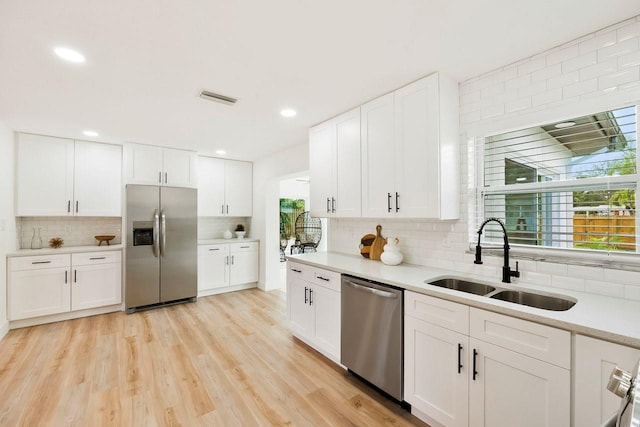 1886 San Mateo Dr, Dunedin, FL 34698 - kitchen featuring backsplash, light countertops, visible vents, a sink, and appliances with stainless steel finishes