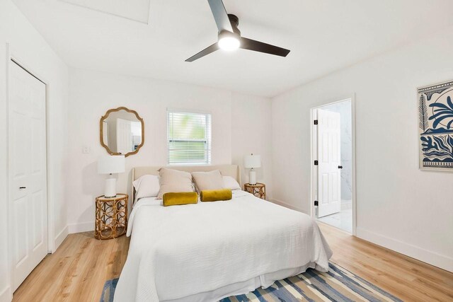1886 San Mateo Dr, Dunedin, FL 34698 - bedroom with light wood finished floors, ensuite bath, baseboards, and a ceiling fan