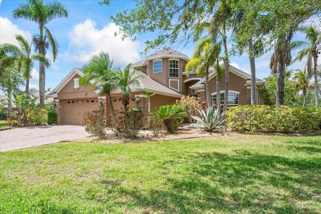 mediterranean / spanish home with an attached garage, driveway, a front yard, and stucco siding