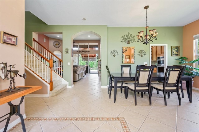 dining area with baseboards, an inviting chandelier, and light tile patterned floors