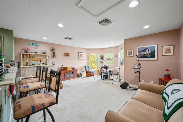 living area featuring recessed lighting, carpet, visible vents, attic access, and a textured ceiling