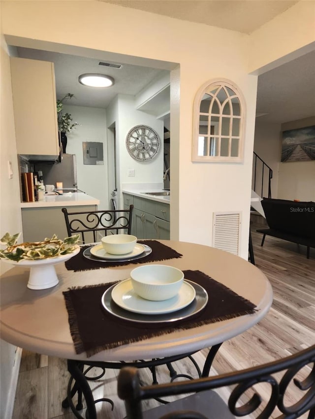 dining room with visible vents, wood finished floors, and stairs