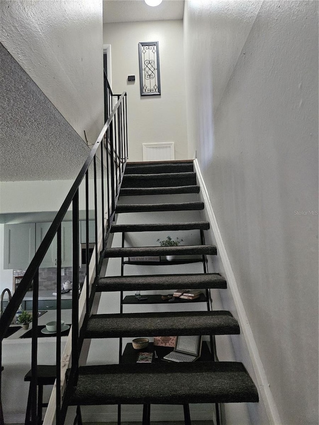 stairs with a textured ceiling