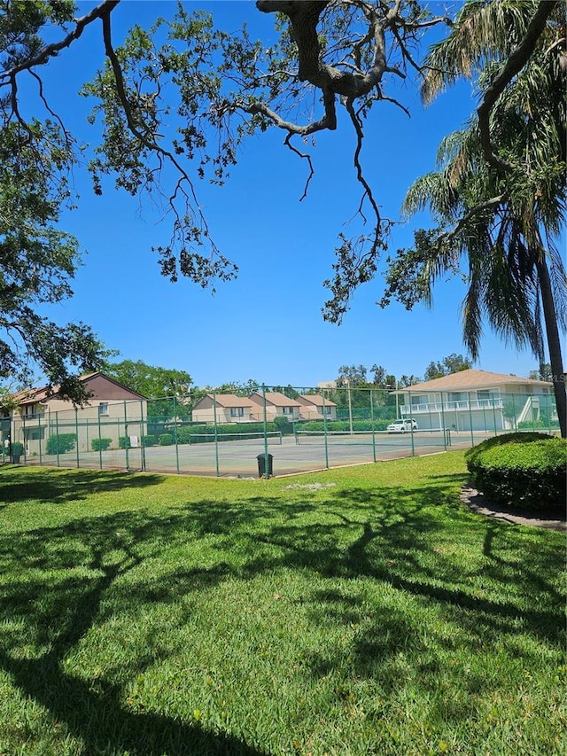 view of sport court with a yard and fence