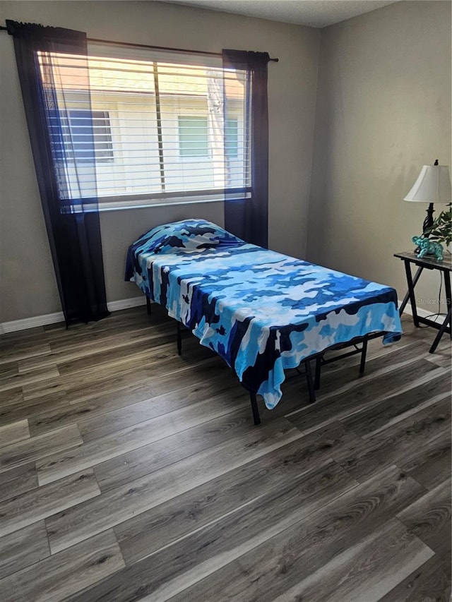 bedroom with wood finished floors and baseboards