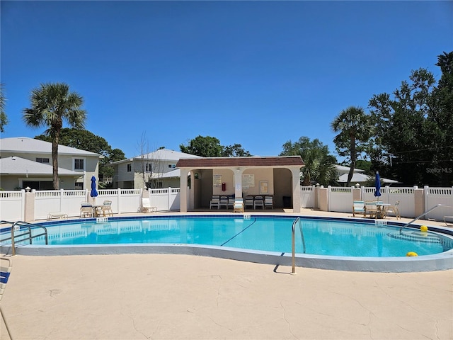 pool with a patio and fence