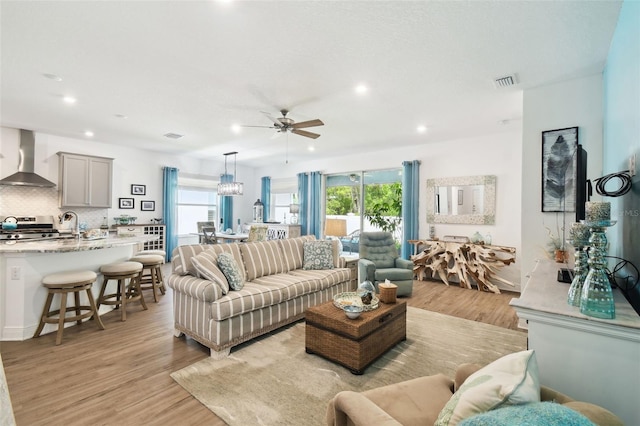 living room with a healthy amount of sunlight, light wood-style flooring, and ceiling fan