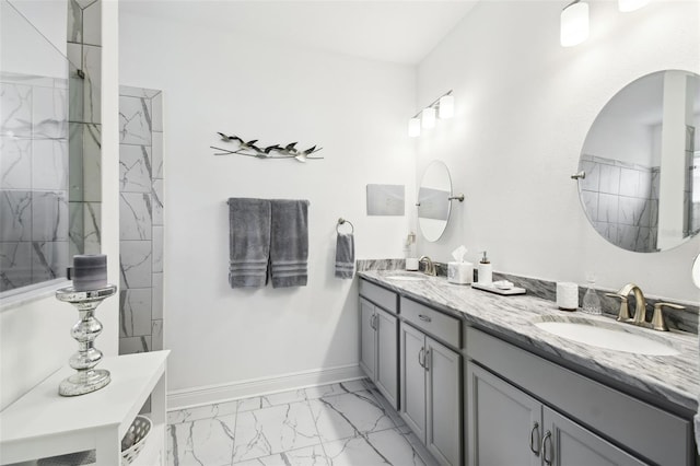 full bathroom with baseboards, a tile shower, marble finish floor, and a sink