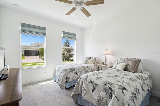 carpeted bedroom featuring ceiling fan and baseboards