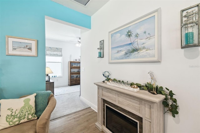 hall featuring light wood finished floors, visible vents, and baseboards