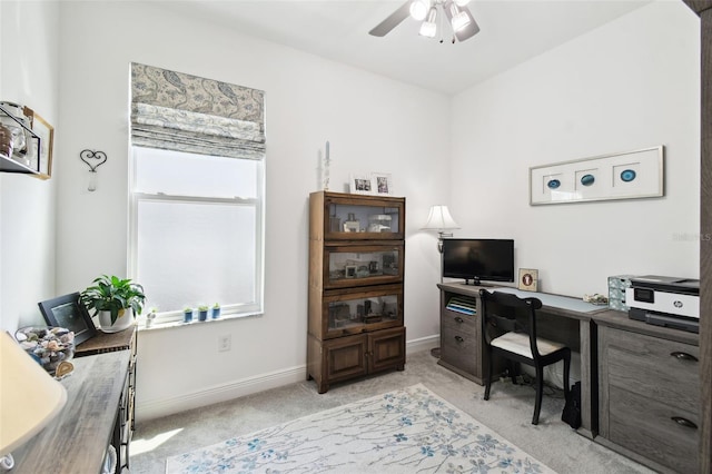office area with ceiling fan, light carpet, and baseboards
