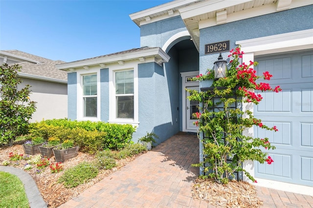 doorway to property featuring stucco siding