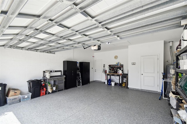garage featuring concrete block wall and a garage door opener
