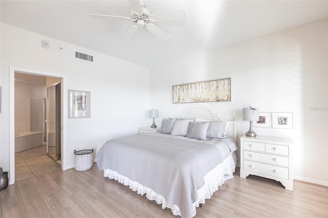bedroom with light wood-style floors, ensuite bath, a ceiling fan, visible vents, and baseboards