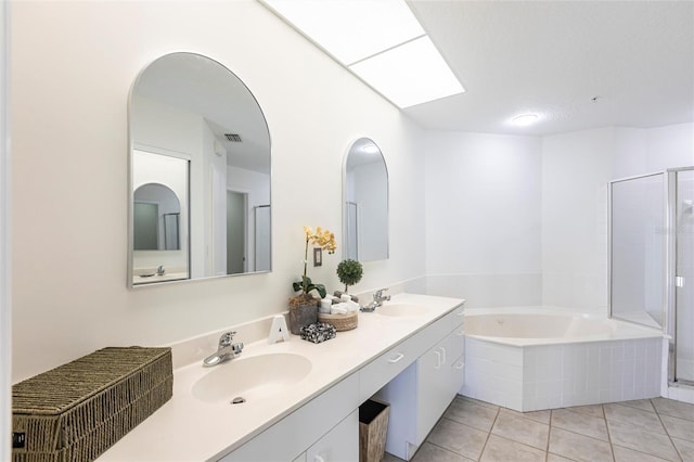 bathroom with a sink, a stall shower, and a garden tub