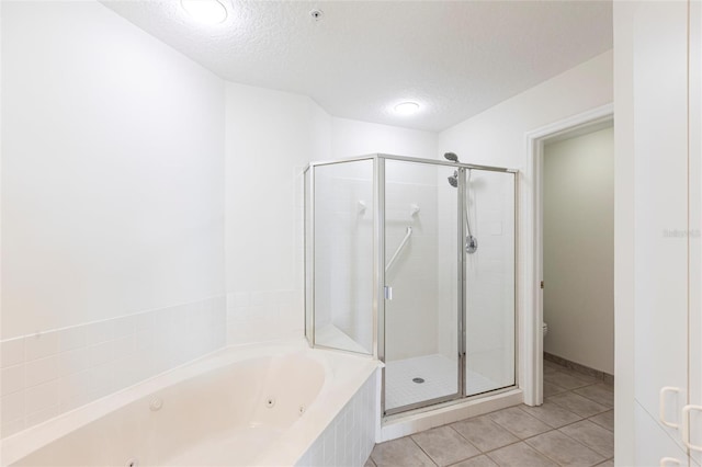 bathroom featuring a shower stall, a tub with jets, and a textured ceiling