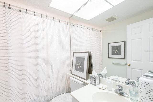 bathroom featuring toilet, vanity, a shower with shower curtain, and visible vents