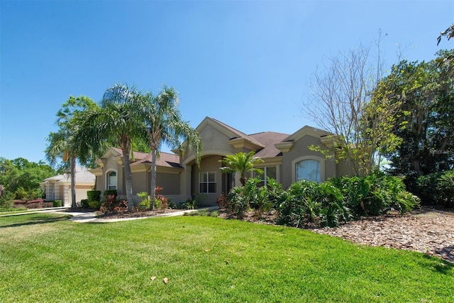 mediterranean / spanish home featuring stucco siding and a front lawn