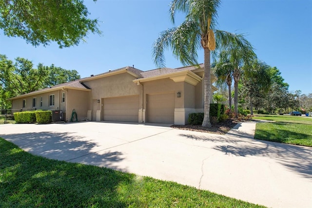ranch-style home with stucco siding, a front lawn, concrete driveway, and an attached garage