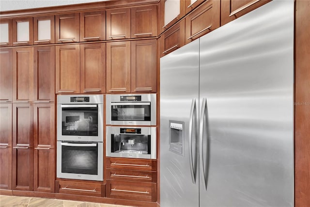 5807 Thoreau Pl, Lithia, FL 33547 - kitchen featuring appliances with stainless steel finishes, brown cabinetry, and glass insert cabinets