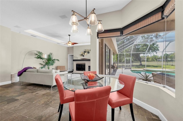 5807 Thoreau Pl, Lithia, FL 33547 - dining area featuring baseboards, ceiling fan, a sunroom, and stone finish flooring