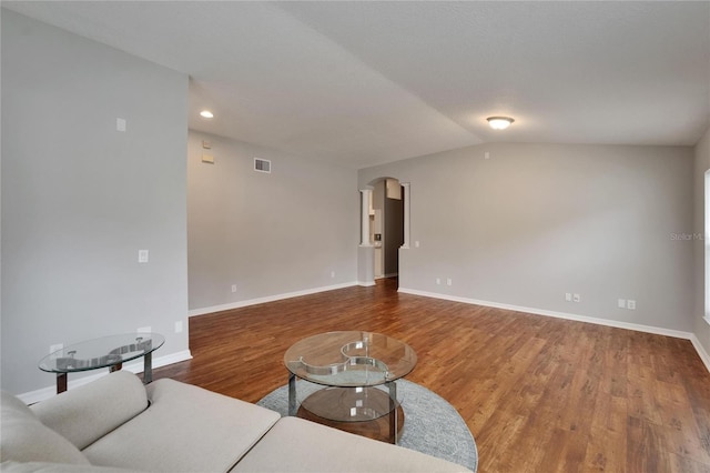 11626 Pure Pebble Dr, Riverview, FL 33569 - unfurnished living room with wood finished floors, baseboards, arched walkways, recessed lighting, and vaulted ceiling