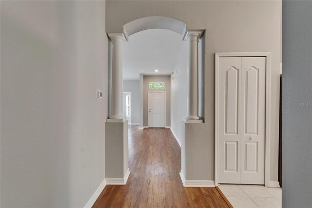 11626 Pure Pebble Dr, Riverview, FL 33569 - hallway featuring decorative columns, light wood-type flooring, baseboards, and arched walkways