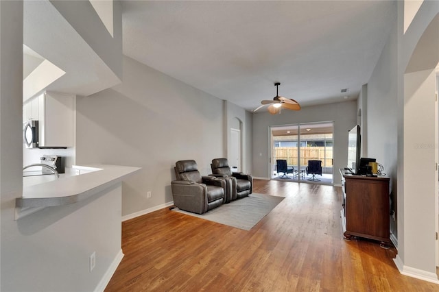 11626 Pure Pebble Dr, Riverview, FL 33569 - living room with arched walkways, baseboards, light wood-type flooring, and ceiling fan