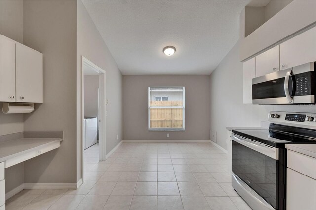 11626 Pure Pebble Dr, Riverview, FL 33569 - kitchen with stainless steel appliances, white cabinetry, light countertops, and baseboards