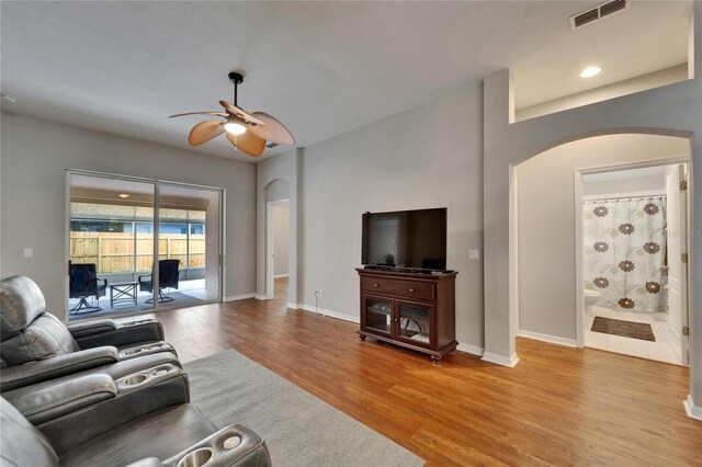 11626 Pure Pebble Dr, Riverview, FL 33569 - living room with arched walkways, a ceiling fan, light wood-type flooring, and baseboards