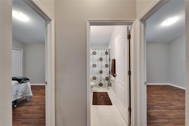 11626 Pure Pebble Dr, Riverview, FL 33569 - corridor with wood finished floors, a textured ceiling, and baseboards