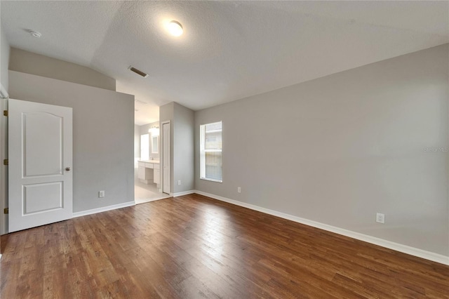 11626 Pure Pebble Dr, Riverview, FL 33569 - unfurnished bedroom featuring wood finished floors, baseboards, vaulted ceiling, and connected bathroom