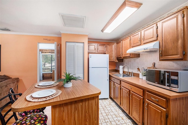 7157 Quail Hollow Blvd, Wesley Chapel, FL 33544 - kitchen featuring freestanding refrigerator, under cabinet range hood, stainless steel microwave, a sink, and light floors