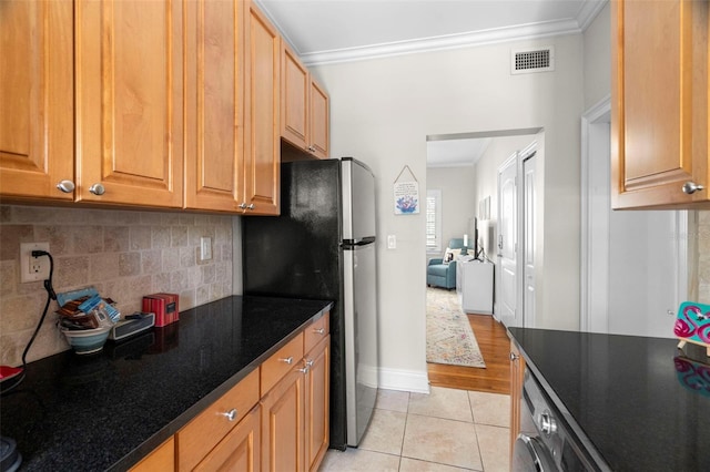2117 W Dekle Ave Unit H1, Tampa, FL 33606 - kitchen with tasteful backsplash, visible vents, light tile patterned floors, freestanding refrigerator, and crown molding